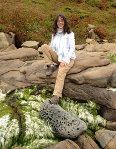 Carolyn Ball sitting on rocks at Pebble Beach.